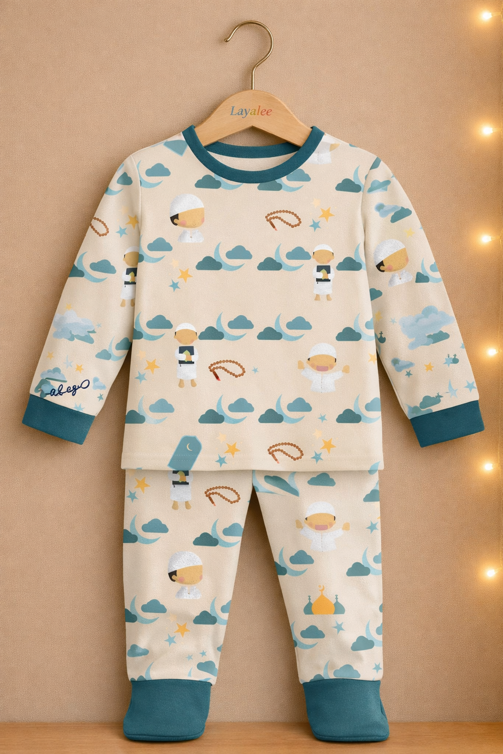 Children's pajama set with whale pattern on a hanger against a beige background